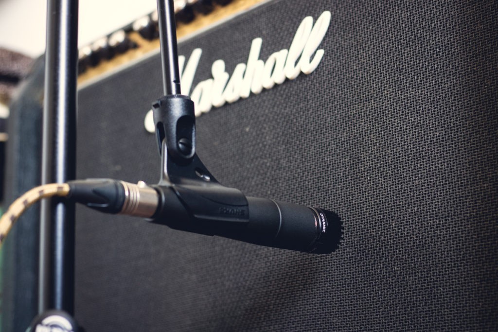 Un microphone enregistrant un ampli de guitare électrique